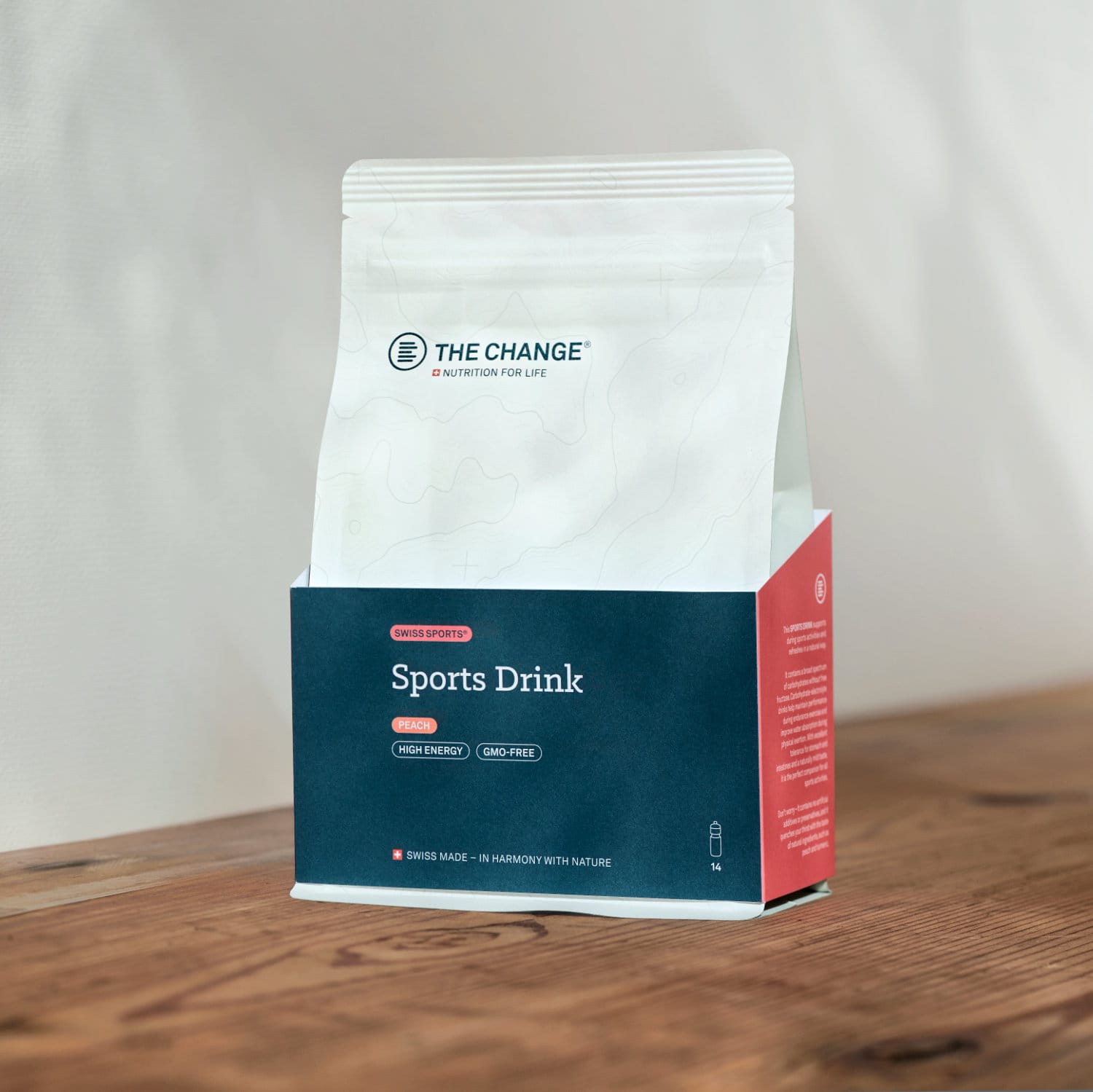 White resealable pouch with red and blue accents, labeled "Sports Drink," high-energy and bio-free, on a wooden surface.