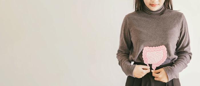 Frau mit einem Darm-Bild über dem Pullover