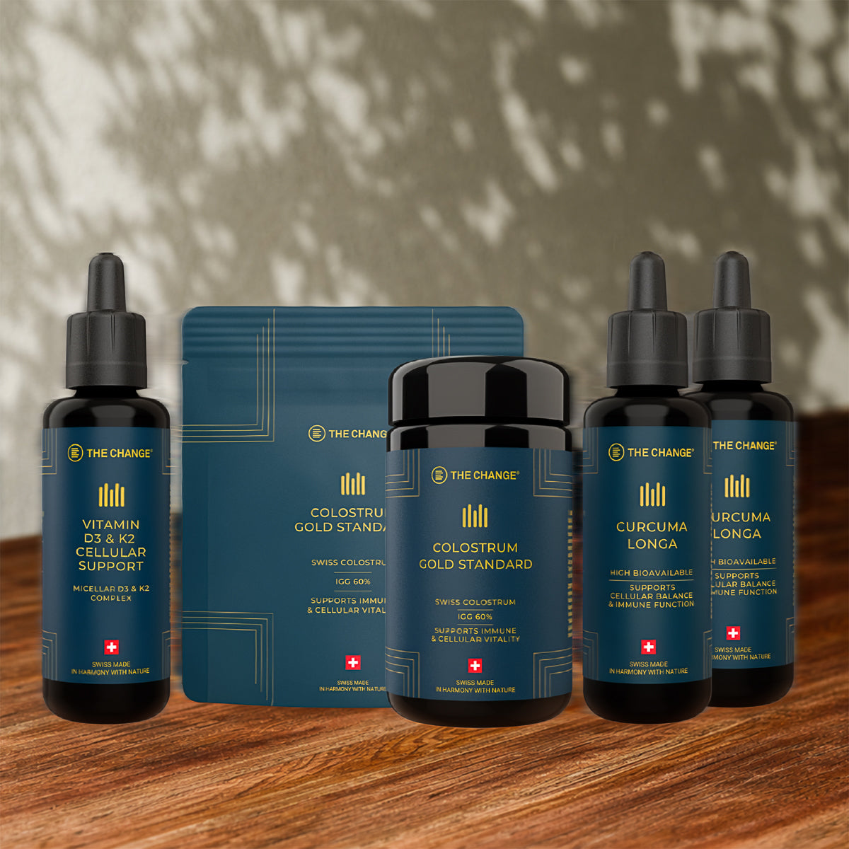 Luxury wellness set featuring dark blue packaging, glass dropper bottles, and gold accents for health support.